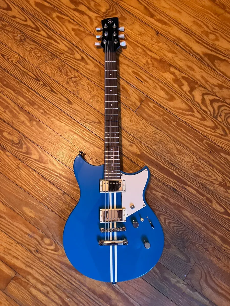 A blue Yamaha Revstar Standard with a white racing stripe, laid on a hardwood floor, with a killswitch toggle and a kill button added alongside the stock controls.